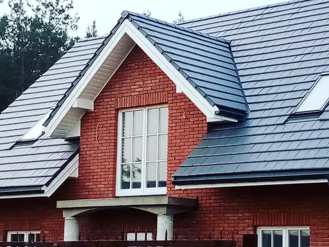 Dom z cegły z ciemnym dachem – realizacja Alpit Dachy